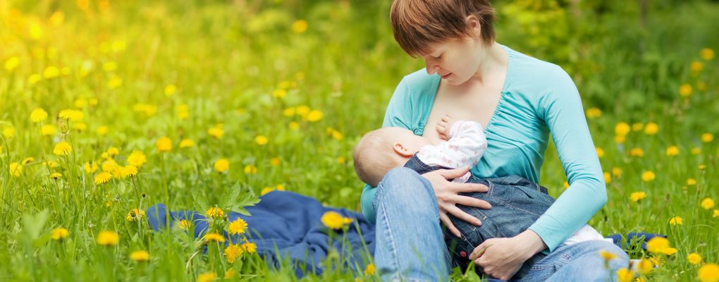 Little baby girl breast feeding outdoor